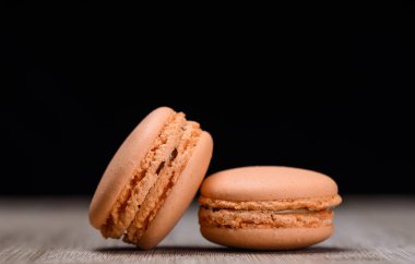 Ahşap arka plan, rustik tarzı üzerinde iki portakal macaroons