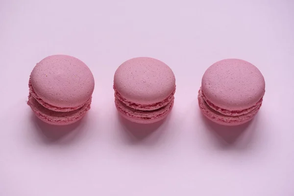 Pink macaroons on pink background close up
