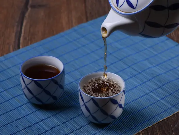 Tee Wird Eine Von Zwei Tassen Gegossen — Stockfoto