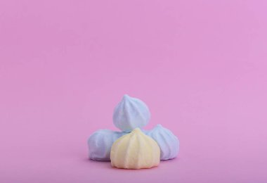 Pembe bir arka plan ve metin için boşaltmak birkaç çok renkli meringues
