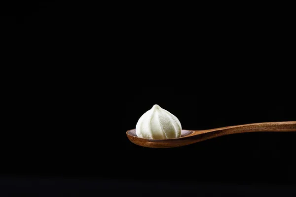 Houten Lepel Met Gele Meringue Geïsoleerd Een Zwarte Achtergrond Close — Stockfoto