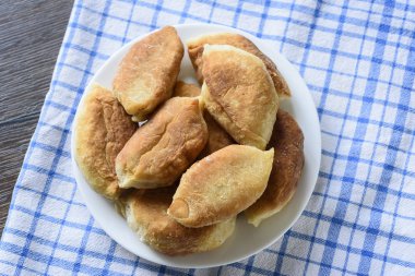 Üstten görünüm. Pişmiş turta bir plaka üzerinde bir mutfak havlusu