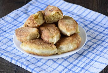Rustik tarzı. Fırında Pasta plaka üzerinde bir mutfak havlusu. Patty yarısıdır üstte