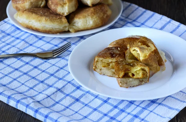 Russian kitchen. Half of the baked pies with potatoes close up