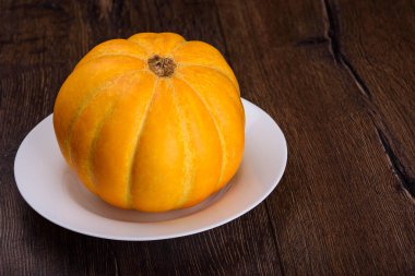 Ahşap arka plan üzerinde beyaz tabakta kavun