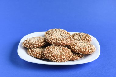 Susam menekşe ba üzerinde beyaz bir tabak yulaf ezmesi kurabiye