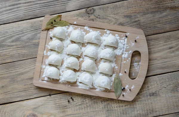 Traditionele schotel van Russische keuken. Pelmeni op een snijplank — Stockfoto