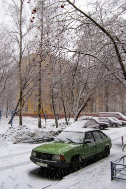 Old green car on a winter snowy day clipart