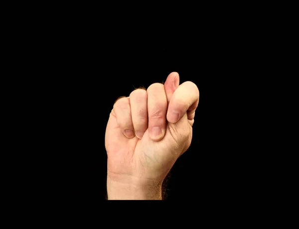 Mans hand shows gesture fig isolated on black