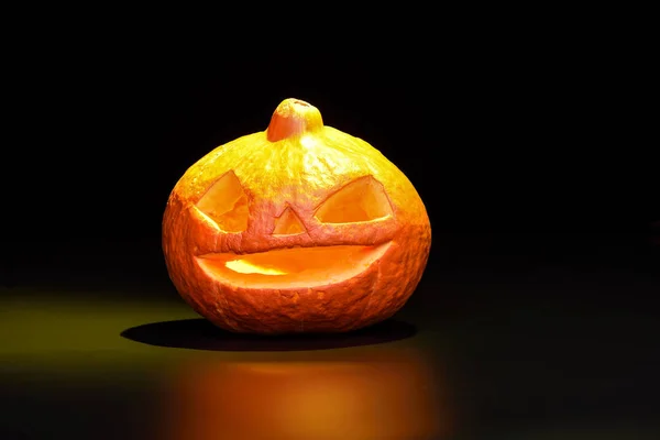 Halloween pumpa isolerad på en svart bakgrund med en gul bakgrundsbelysning — Stockfoto