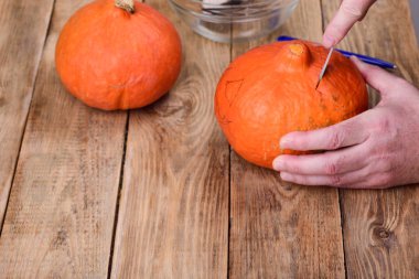 Bir delik kesme. Cadılar Bayramı için bir balkabağı fener yapma.