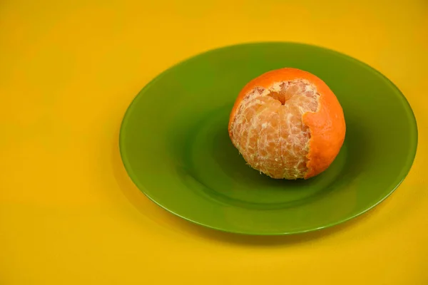 Leicht Geschälte Mandarine Auf Einem Grünen Teller Auf Gelbem Hintergrund — Stockfoto