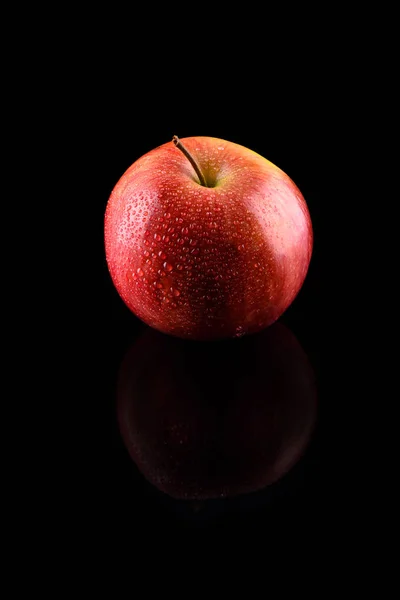 Pomme rouge mûre avec gouttes d'eau sur fond noir avec refle — Photo