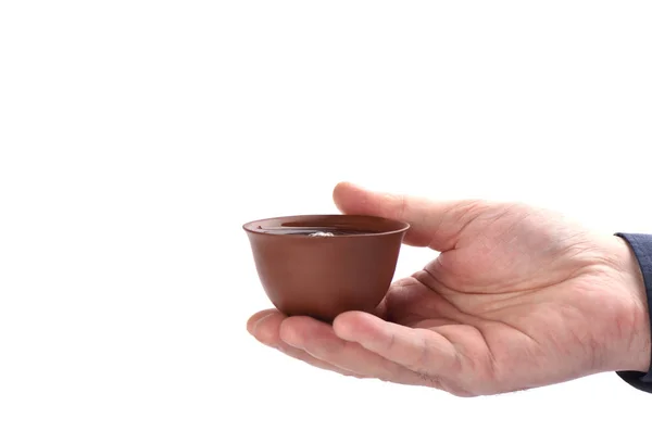 Kínai agyag tea csésze tea a kezében egy fehér háttér. — Stock Fotó