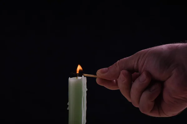 Emberi kéz egy égő gyufa a fény egy gyertyát — Stock Fotó