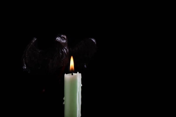 燃烧的淡绿色蜡烛照亮了鹰的形状, 我 — 图库照片