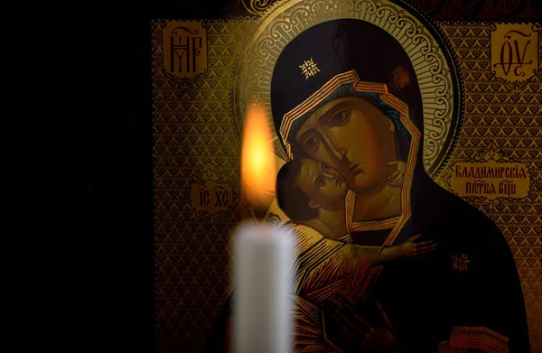 Icône orthodoxe de la Mère de Dieu et de l'Enfant Jésus et une bougie floue devant l'icône — Photo