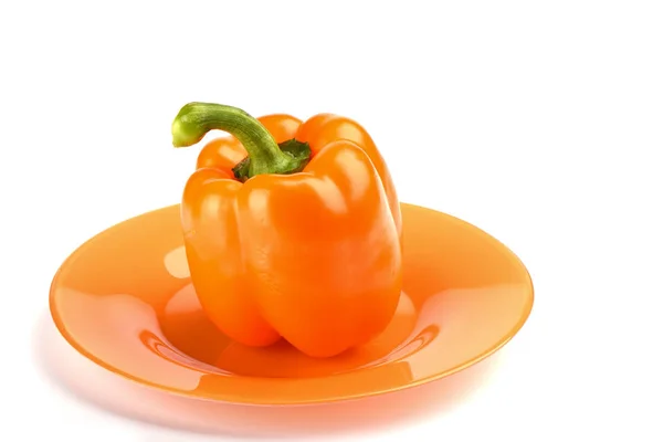 Pimenta laranja no prato laranja sobre fundo branco. Local — Fotografia de Stock