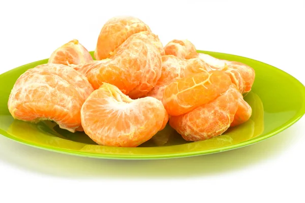 Fette sbucciate di mandarino su un piatto verde su fondo bianco — Foto Stock