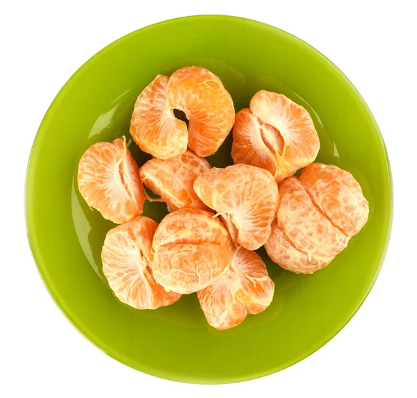 Vista superior. Rebanadas peladas de mandarina en un plato verde sobre un fondo blanco . — Foto de Stock