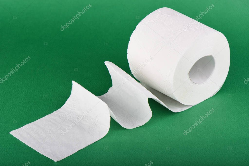 Roll of toilet paper isolated on green background