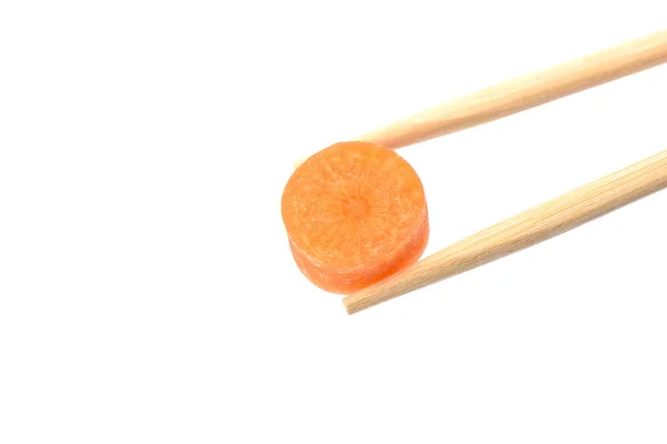 Палочки для еды с кругом спелых морковок, изолированных на белом спинке — стоковое фото