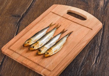 Çeşitli Baltık Ringa balığı soğuk ahşap bir kesme tahtasında füme.