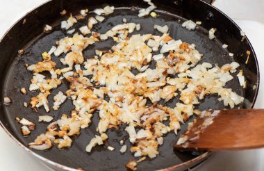 Bir tavada bitkisel yağ ile doğranmış soğan kızartın. Ahşap spatula ile soğan karıştırma.