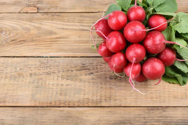 Ahşap arka planda taze turp. Ahşap bir arka plan üzerinde yaprakları ile turp Demet.