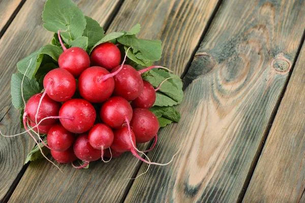 Ahşap arka planda taze turp. Ahşap bir arka plan üzerinde yaprakları ile turp Demet.