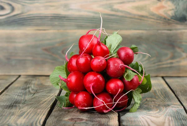 Ahşap arka planda taze turp. Ahşap bir arka plan üzerinde yaprakları ile turp Demet.