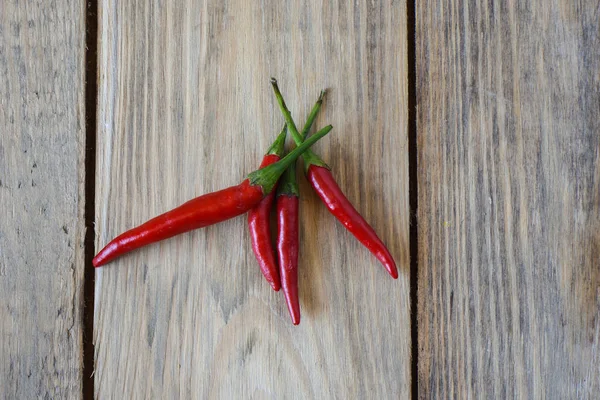 Pods of red hot pepper on wooden background.