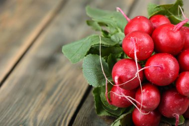 Ahşap arka planda taze turp. Ahşap bir arka plan üzerinde yaprakları ile turp Demet.