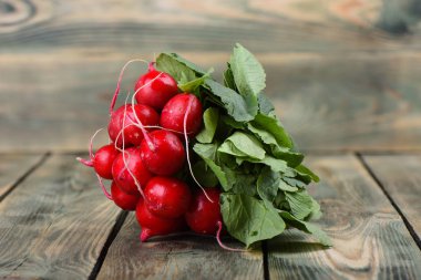 Ahşap arka planda taze turp. Ahşap bir arka plan üzerinde yaprakları ile turp Demet.