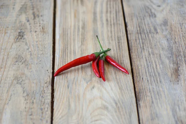 Pods of red hot pepper on wooden background. — Stock Photo, Image