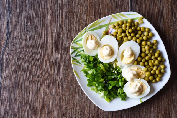 Gekookte eieren onder mayonaise met groene erwten en groene uien. Een traditioneel Russisch gerecht. — Stockfoto