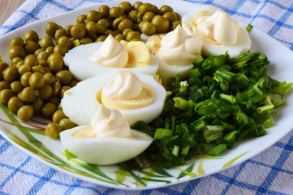 Œufs cuits sous mayonnaise avec pois verts et oignons verts. Un plat traditionnel russe . — Photo