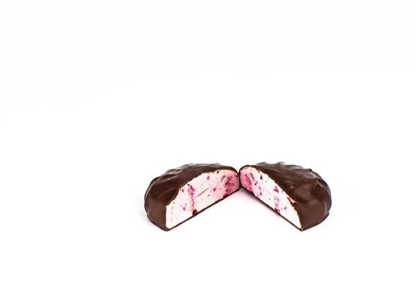 Skåret i to stykker skumfiduser i chokoladeglasur. Souffle med solbær . - Stock-foto