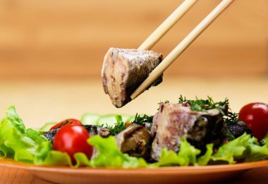 Bir dilim sardalyayla yemek çubukları. Yakın çekim