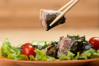 Bir dilim sardalyayla yemek çubukları. Yakın çekim