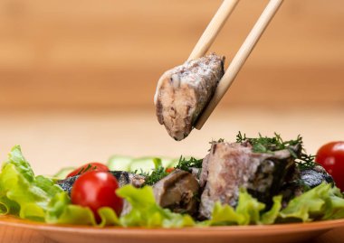 Bir dilim sardalyayla yemek çubukları. Yakın çekim