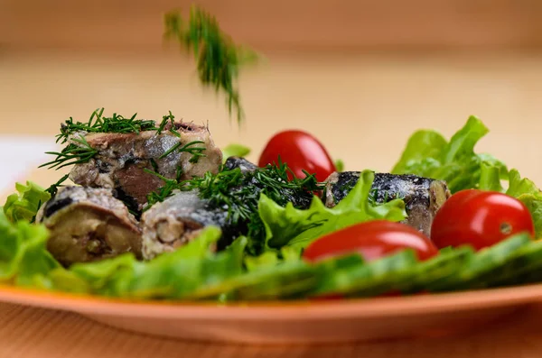 Trozos de sardina iwashi en hojas de lechuga con tomates rojos . — Foto de Stock