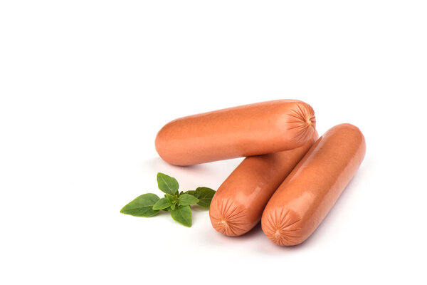 Три свежих вареных сосиски с базиликом на белом фоне
