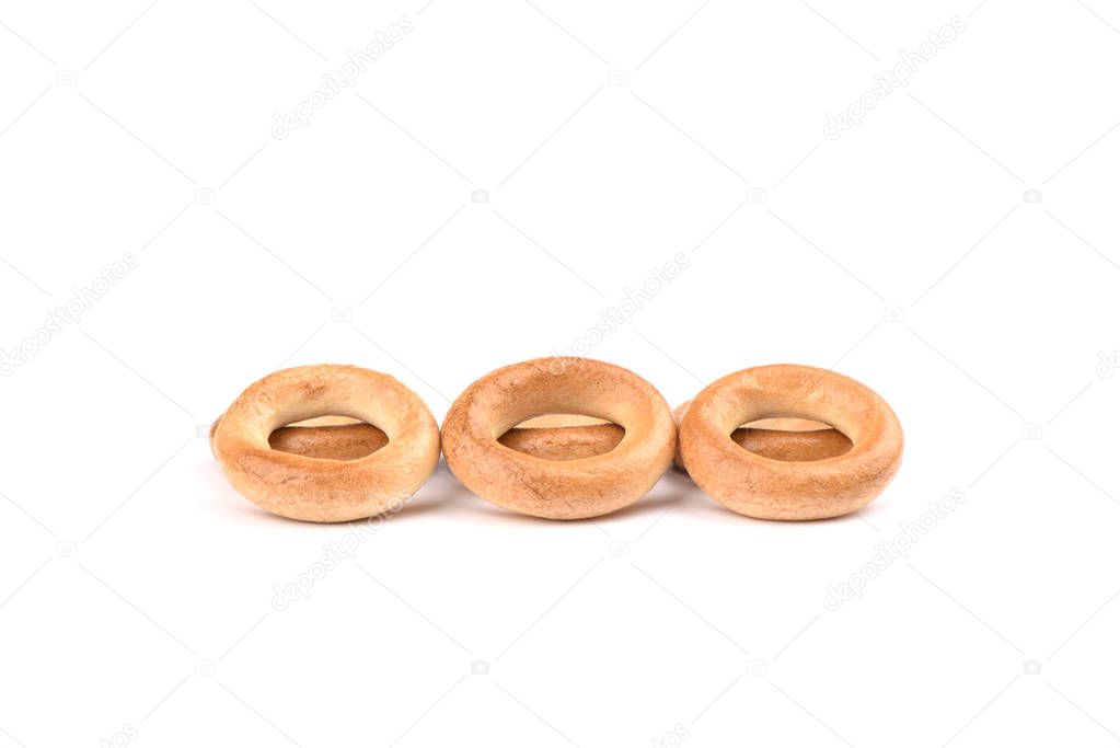 Several crispy bagels isolated on white background.