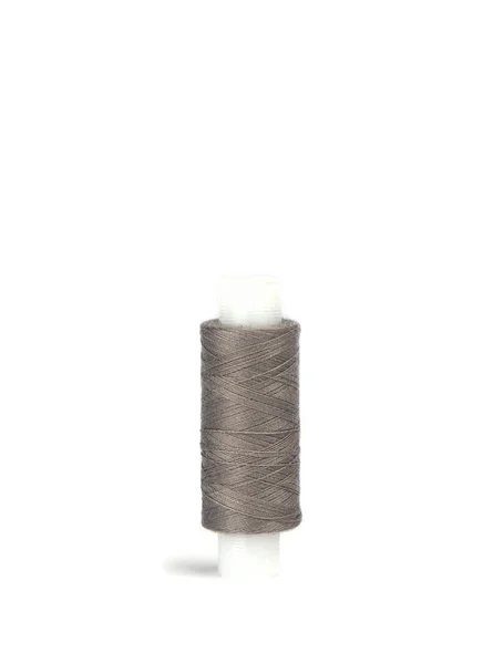 Baumwollgraue Fäden auf der Kunststoffhülle für die Nähmaschine. — Stockfoto