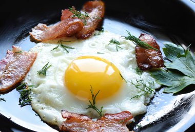 Bir balck plat biraz kızarmış pastırma ve maydanoz ile kızarmış yumurta