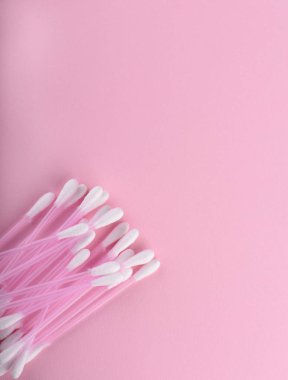 Pamuk tomurcukları pembe bir arka plan üzerinde. Hijyenik malzemeler.