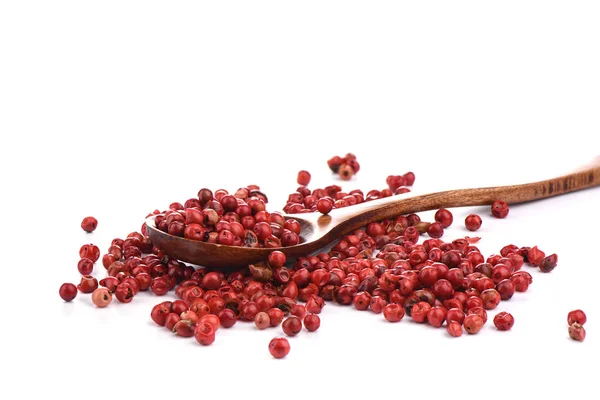 Guisantes de pimiento rojo sobre una cuchara culinaria de madera aislada sobre un fondo blanco . — Foto de Stock