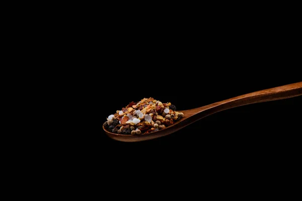 Blandning av kryddor för kulinariska kvarn på träsked över svart b — Stockfoto
