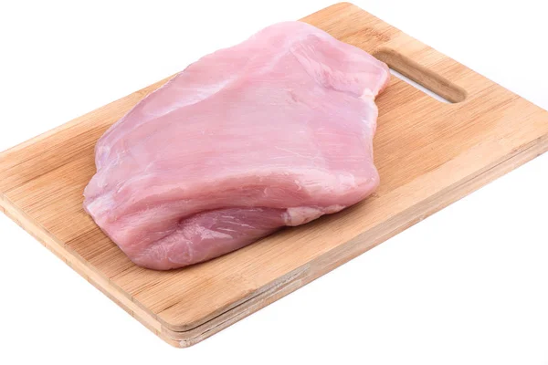 Raw turkey fillet on wooden cutting board over white background. — Stock Photo, Image